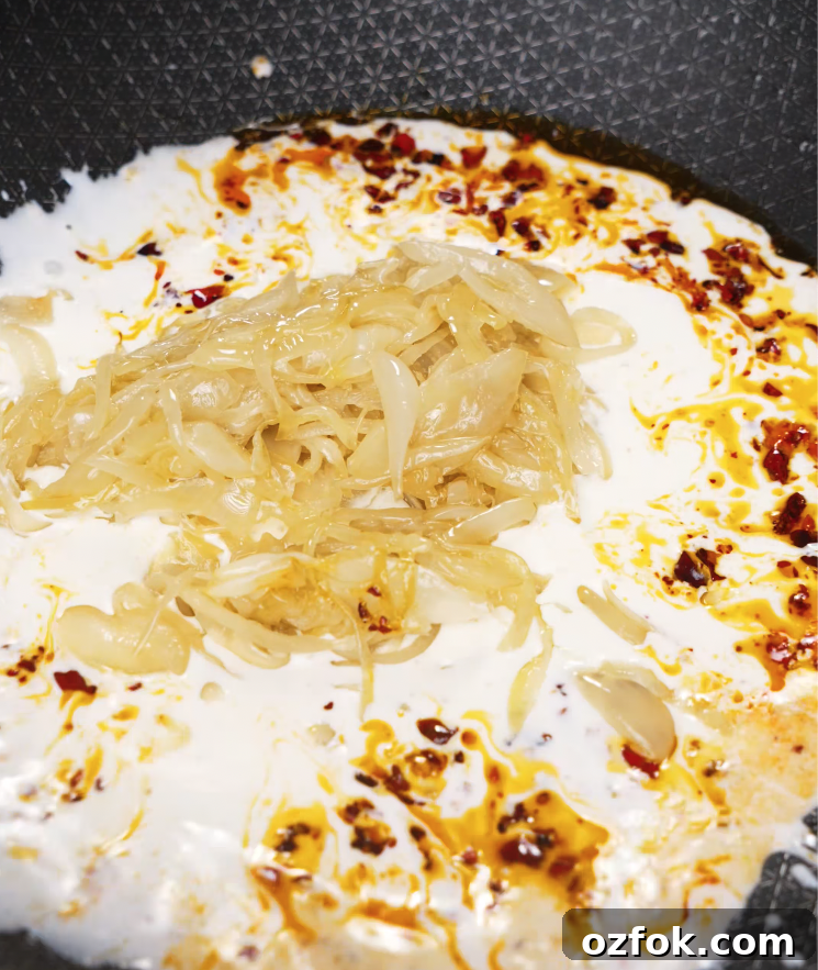 Chili Oil & Caramelized Onion Pasta Recipe for Flavorful Dinner 6 Caramelized onions added to a creamy chili oil sauce in a pan to build the flavor base.