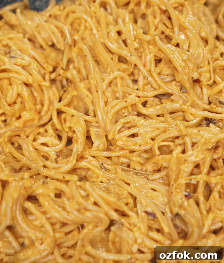 Chili Oil & Caramelized Onion Pasta Recipe for Flavorful Dinner 7 Spaghetti fully mixed into the rich, creamy chili oil sauce, coating each noodle evenly.