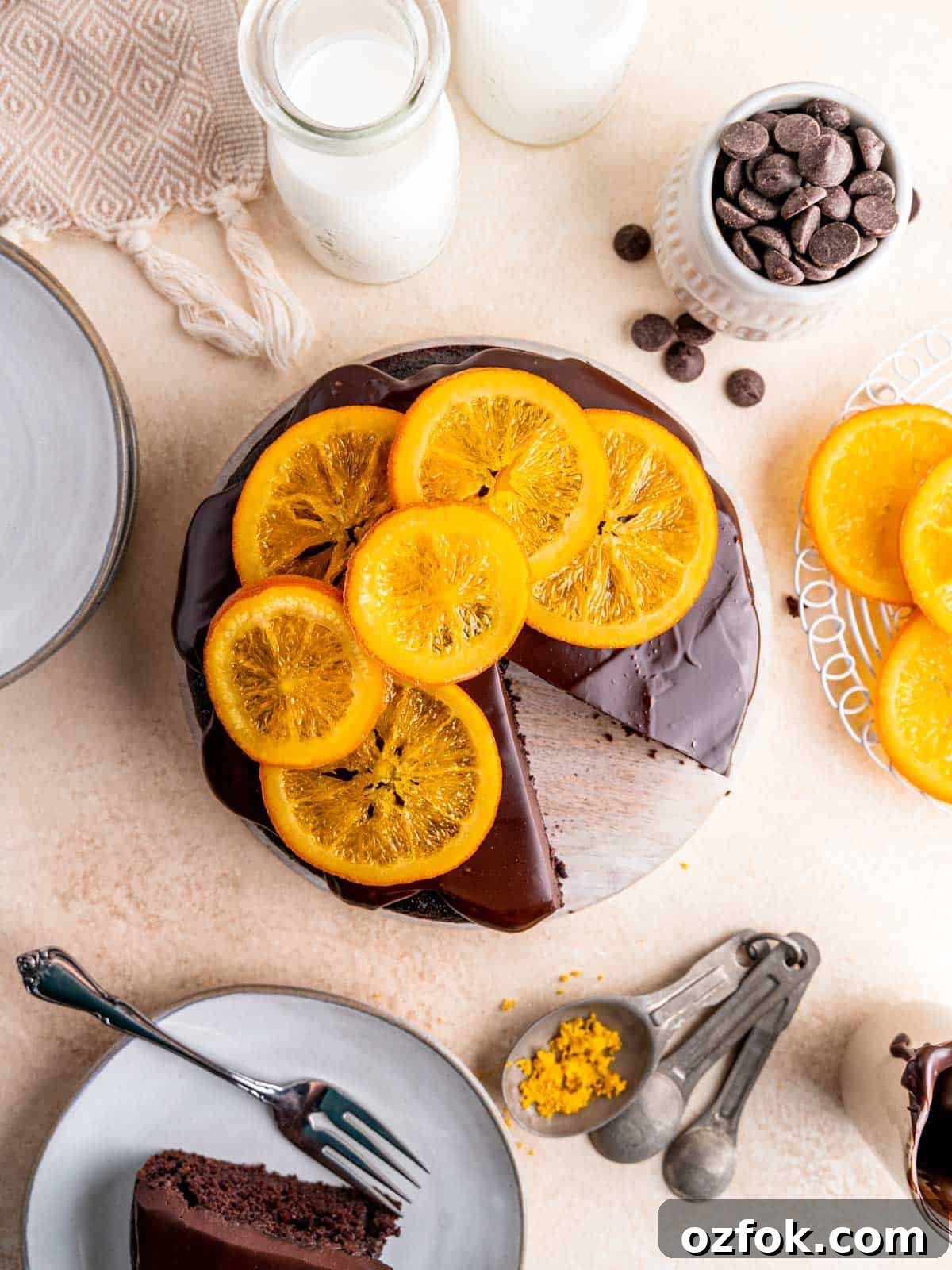 Flatlay of an orange chocolate cake with ganache frosting and candied oranges on top.