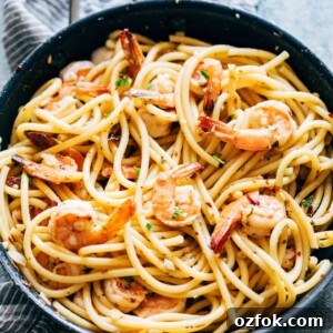 Shrimp Spaghetti Aglio Olio garnished with parsley, parmesan and served in a bowl.