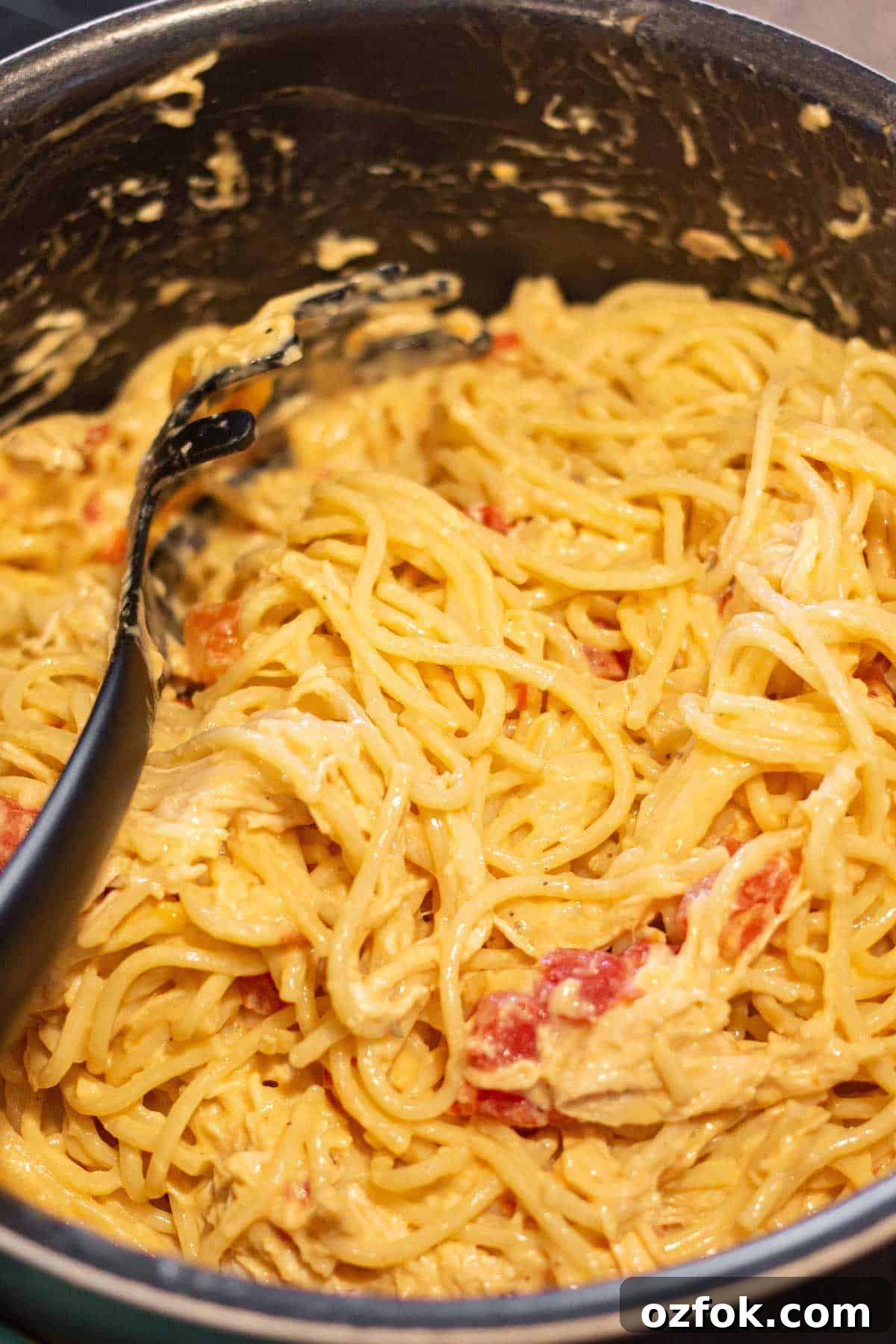 Creamy Rotel Chicken Spaghetti with Velveeta Cheese 6 Cooked shredded chicken, al dente spaghetti, and the Rotel cheese mixture combined in a large pot.