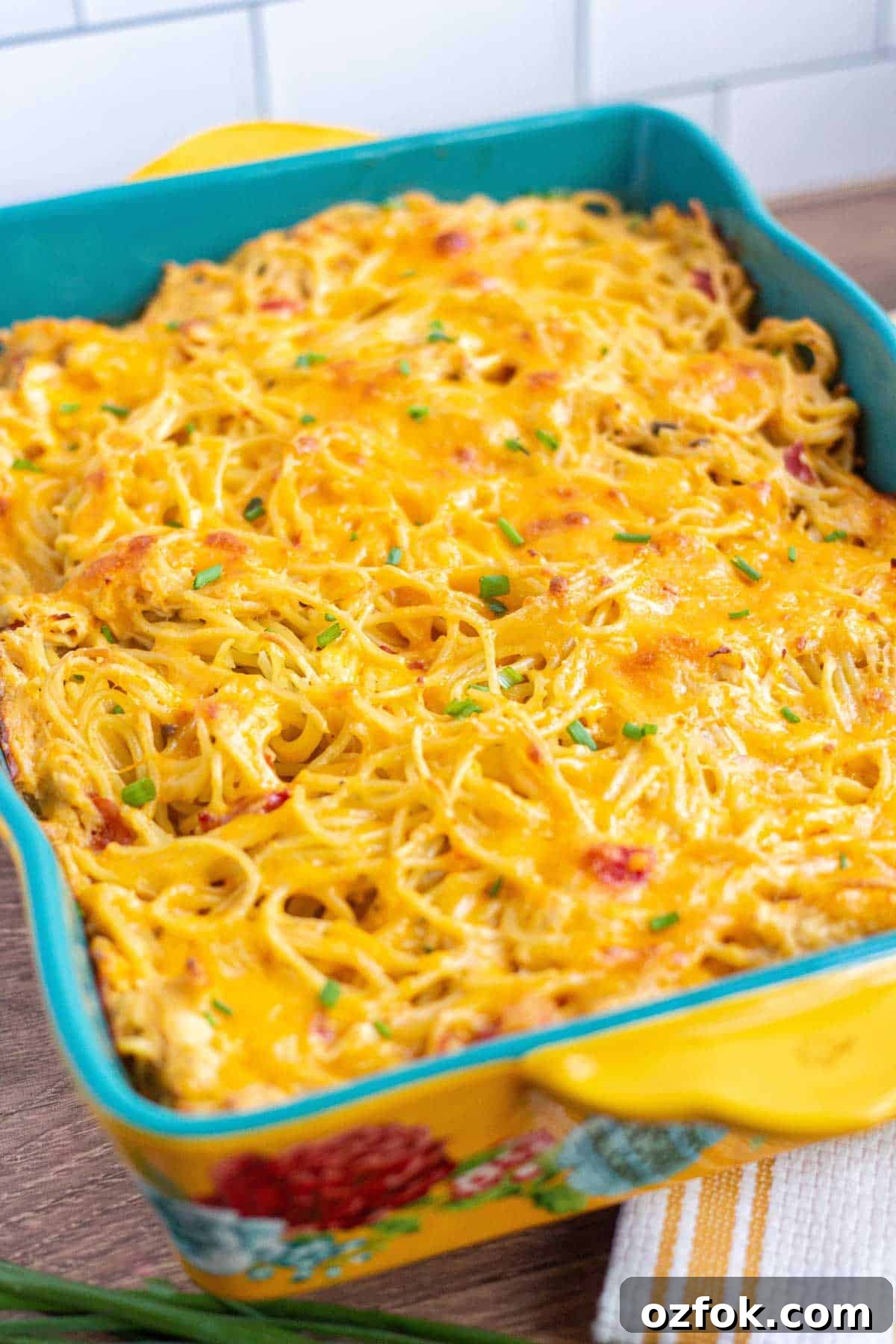 Creamy Rotel Chicken Spaghetti with Velveeta Cheese 10 Rotel chicken spaghetti baked in a 9x13 dish and garnished with chives.