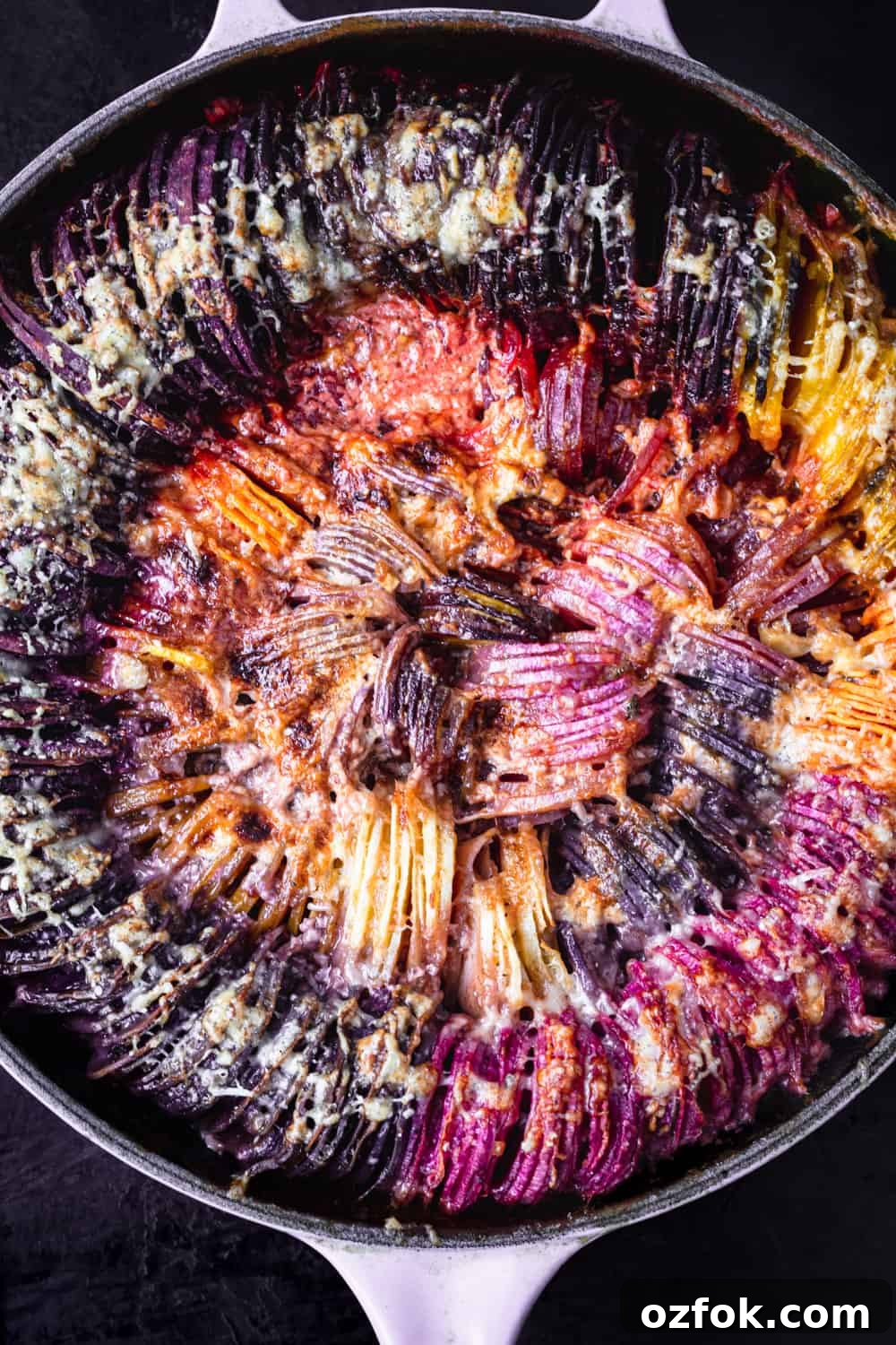 Crispy Hasselback Potato Gratin: Creamy Layered Comfort Dish 9 Rainbow root veggie hasselback gratin; there's purple, red, orange, yellow and white root veggies; post oven and overhead shot.