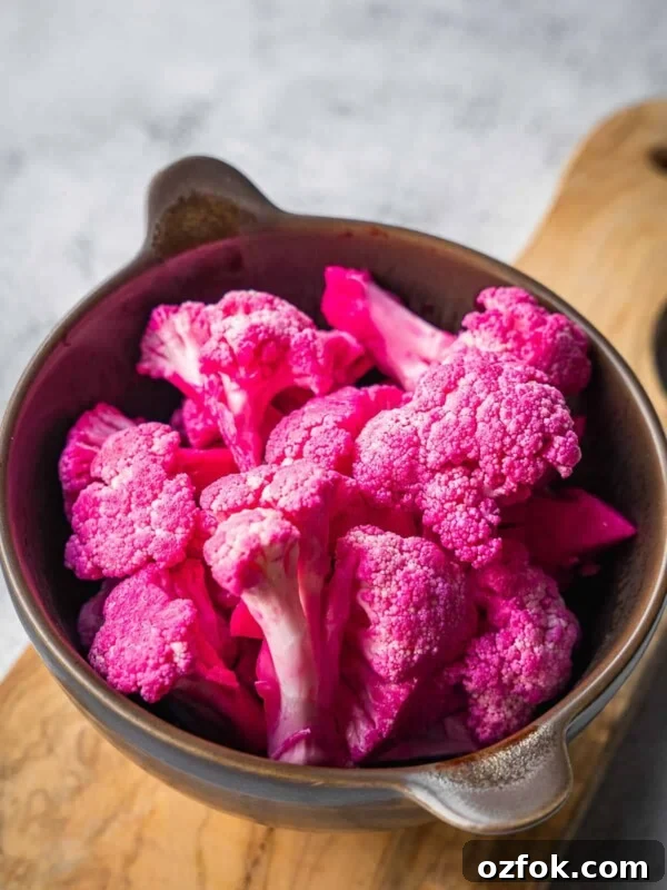 A bowl with pickled pink cauliflower florets.
