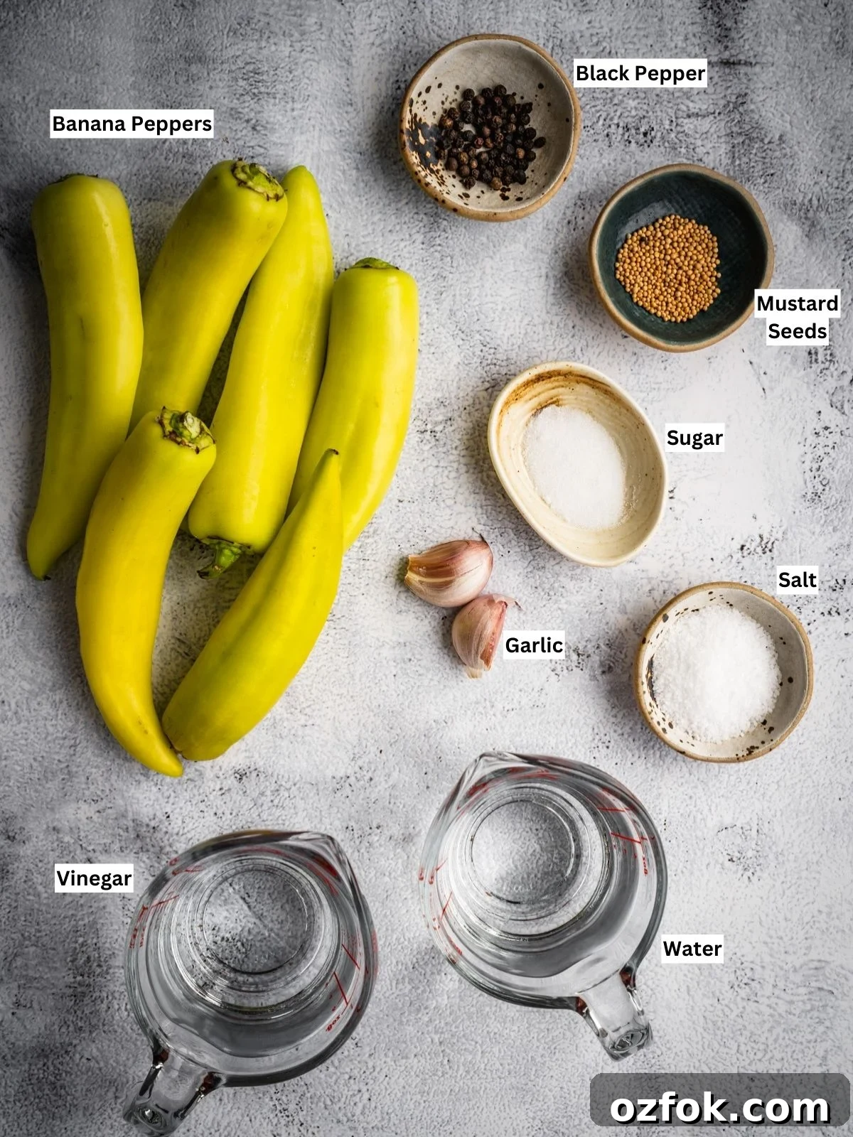 Pickled banana peppers recipe ingredients with individual labels on a board.