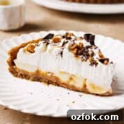 Banoffee Tart Recipe: Caramelized Banana Tart with Buttery Crust 18 A slice of banoffee tart on a plate showing layers of dulce de leche, bananas and whipped cream.
