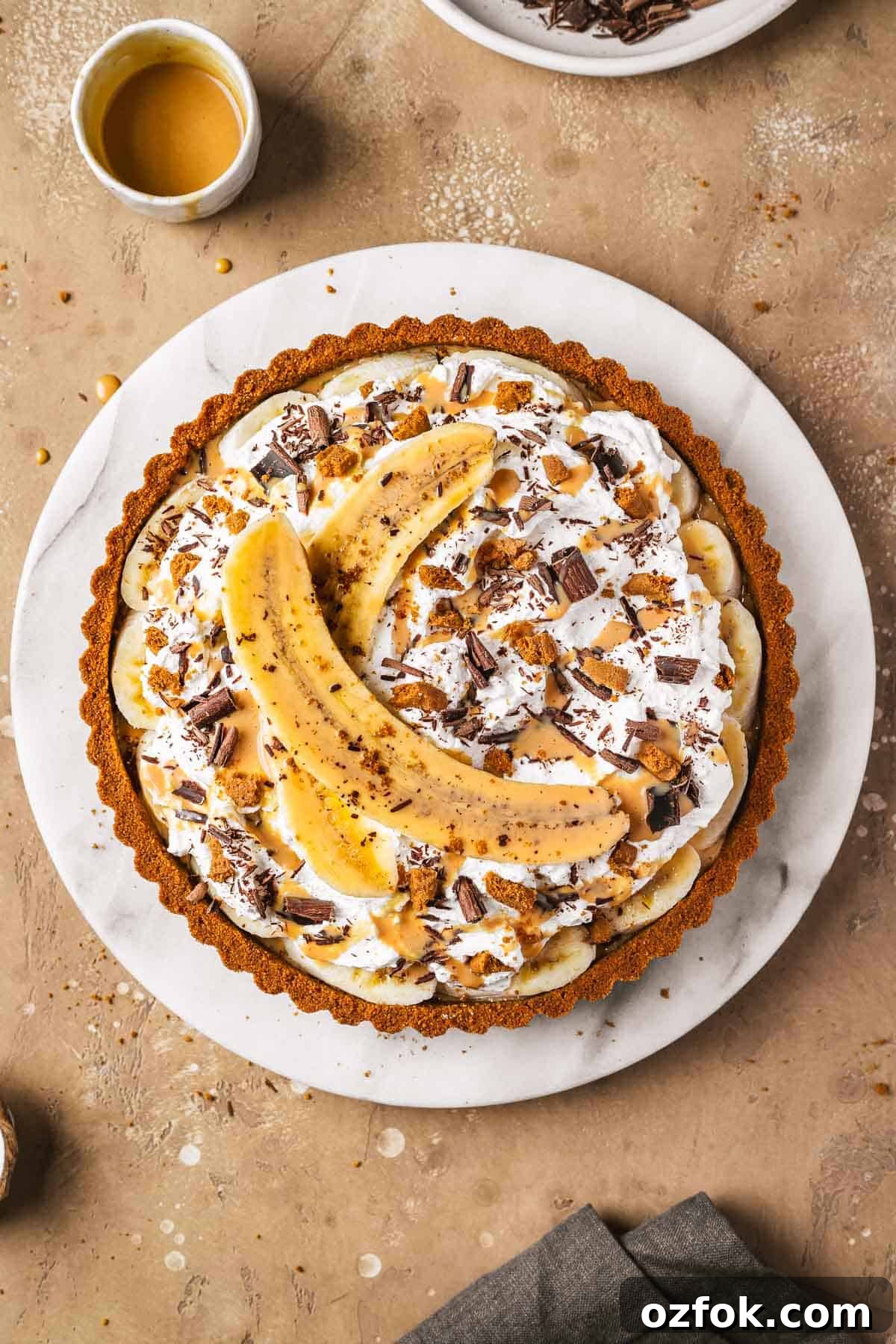 Banoffee Tart Recipe: Caramelized Banana Tart with Buttery Crust 3 A caramel banana tart on a marble platter.