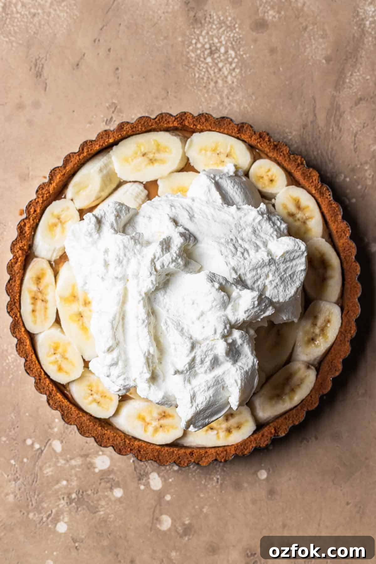 Banoffee Tart Recipe: Caramelized Banana Tart with Buttery Crust 10 Whipped cream on top of a biscoff tart crust filled with dulce de leche and bananas.