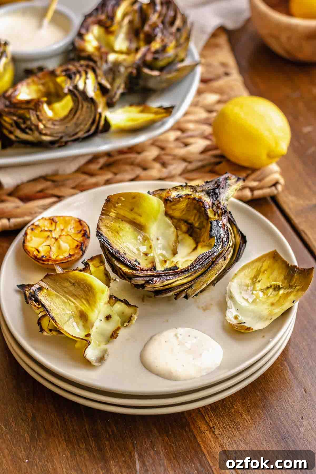 Grilled Marinated Artichokes with Lemon Aioli Recipe 16 Half a grilled artichoke on a plate with leaves removed.