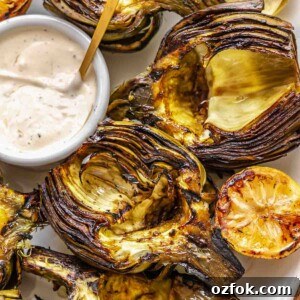 Grilled Marinated Artichokes with Lemon Aioli Recipe 21 Grilled artichokes on a platter with dipping sauce.