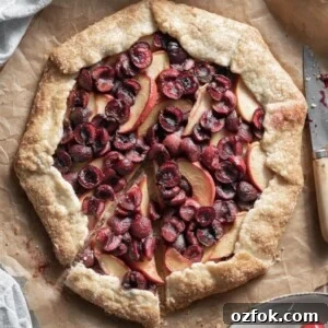 Peach and Cherry Galette Recipe with Flaky Golden Crust 5 Closeup of a cherry and peach galette with a slice cut.