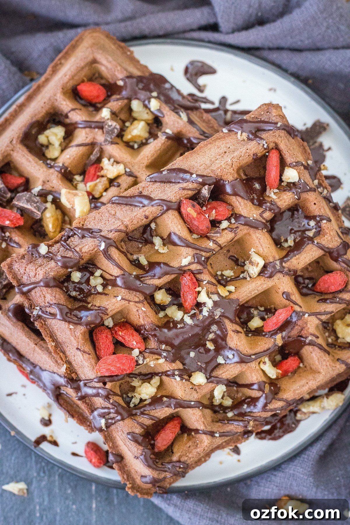 Decadent Chocolate Waffle Recipe for Breakfast or Dessert 5 Upper view of a Chocolate waffles served on a plate drizzled with melted chocolate