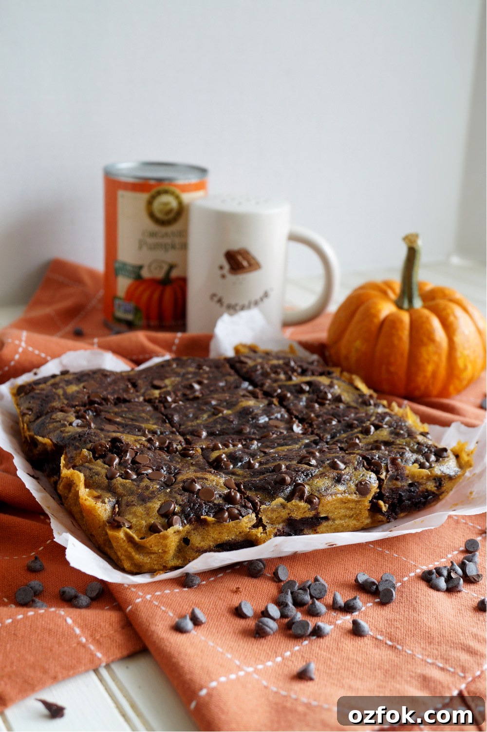 Vegan Pumpkin Swirl Brownies Recipe — Moist & Decadent 2 pumpkin swirl brownies on orange towel