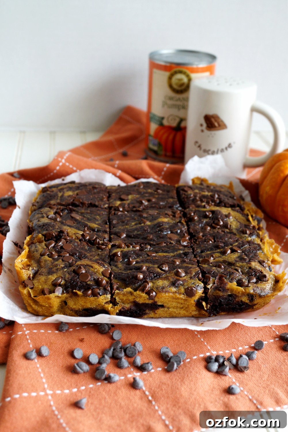 Vegan Pumpkin Swirl Brownies Recipe — Moist & Decadent 5 head-on shot of pumpkin swirl brownies on parchment