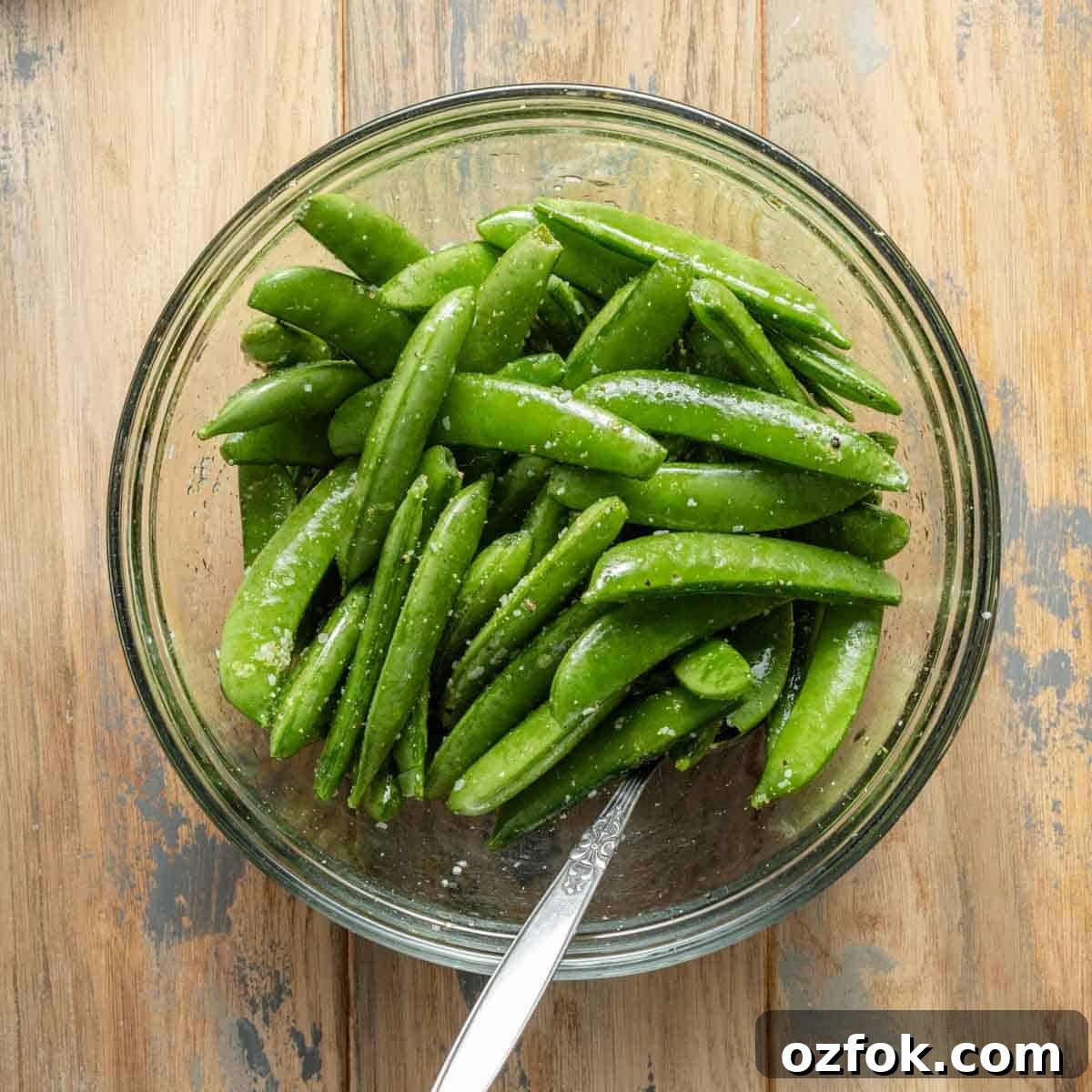 Crispy Air-Fried Snap Peas Recipe (15-Minute Side) 4 Snap peas in bowl mixed with oil and seasonings.
