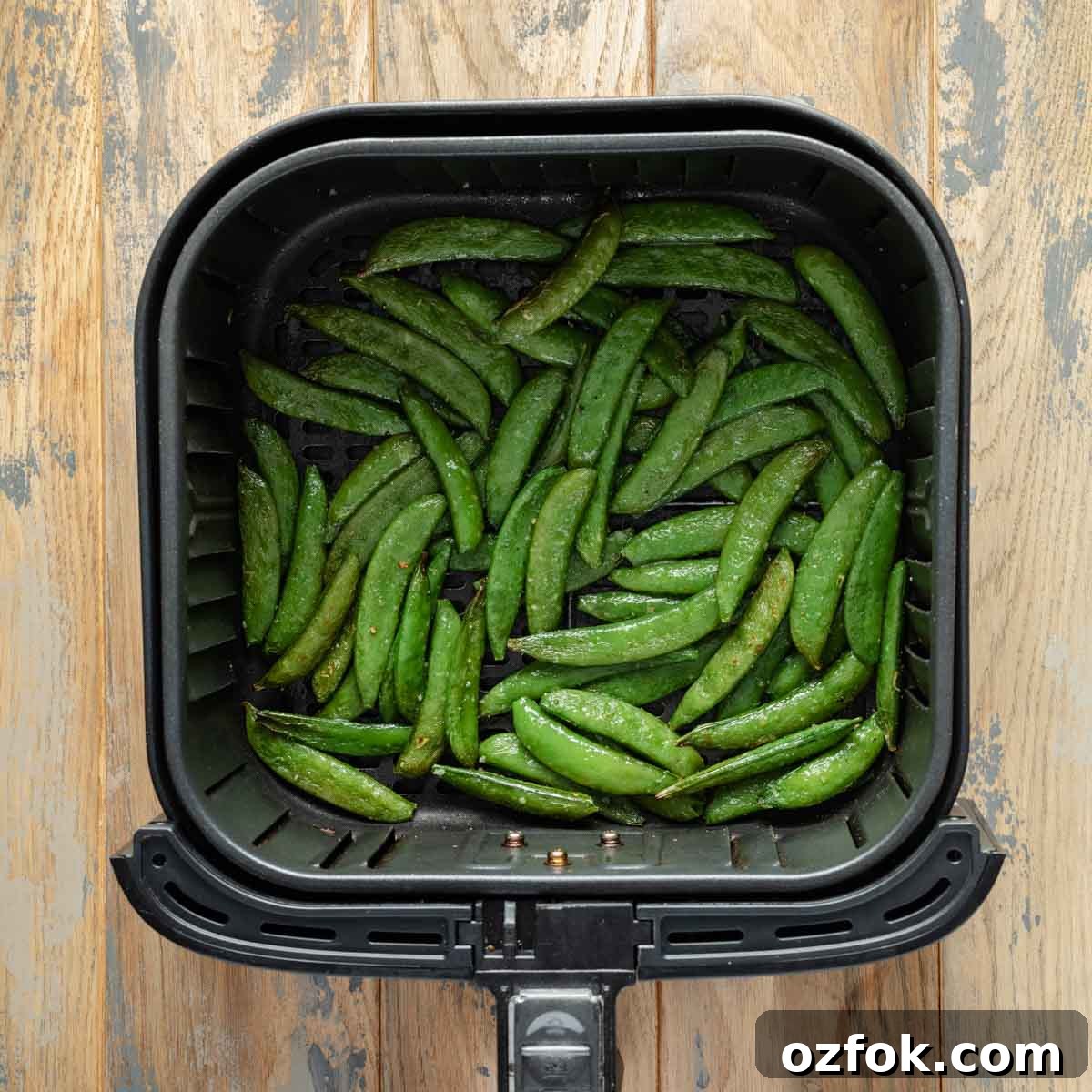 Crispy Air-Fried Snap Peas Recipe (15-Minute Side) 6 Air fried snap peas in air fryer basket.