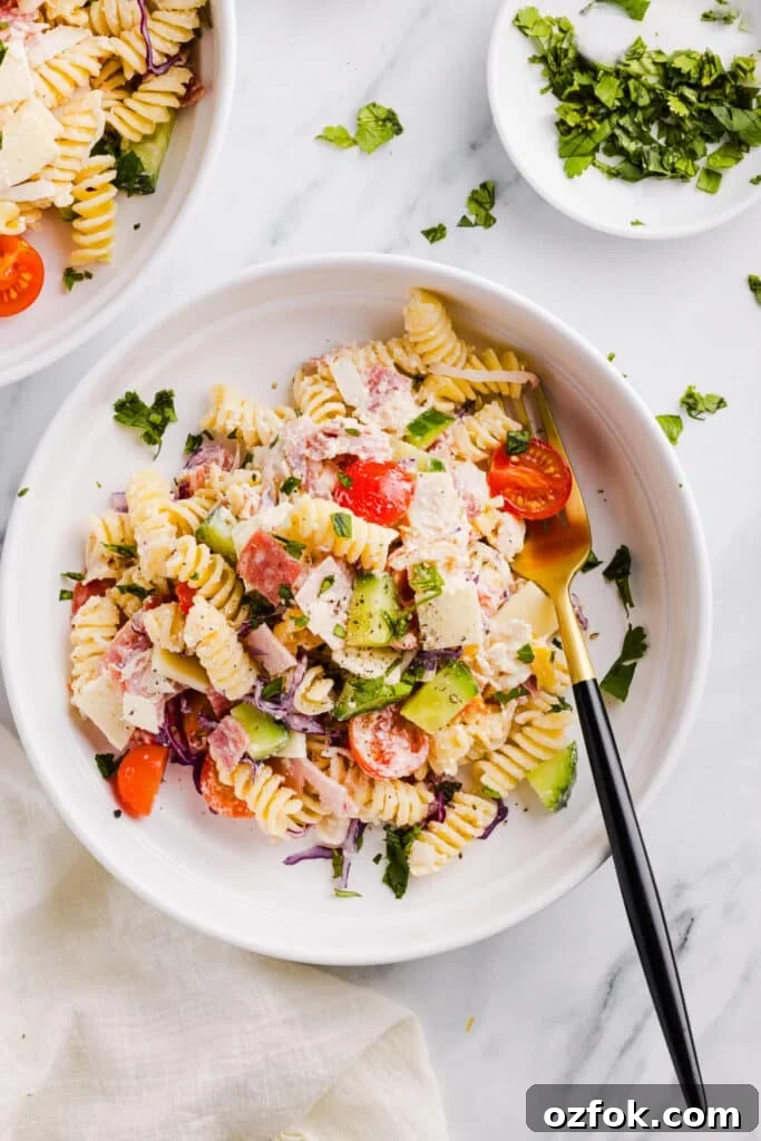 Grinder Pasta Salad Recipe with Italian Meats and Cheese 4 Grinder pasta salad on a plate with a fork.