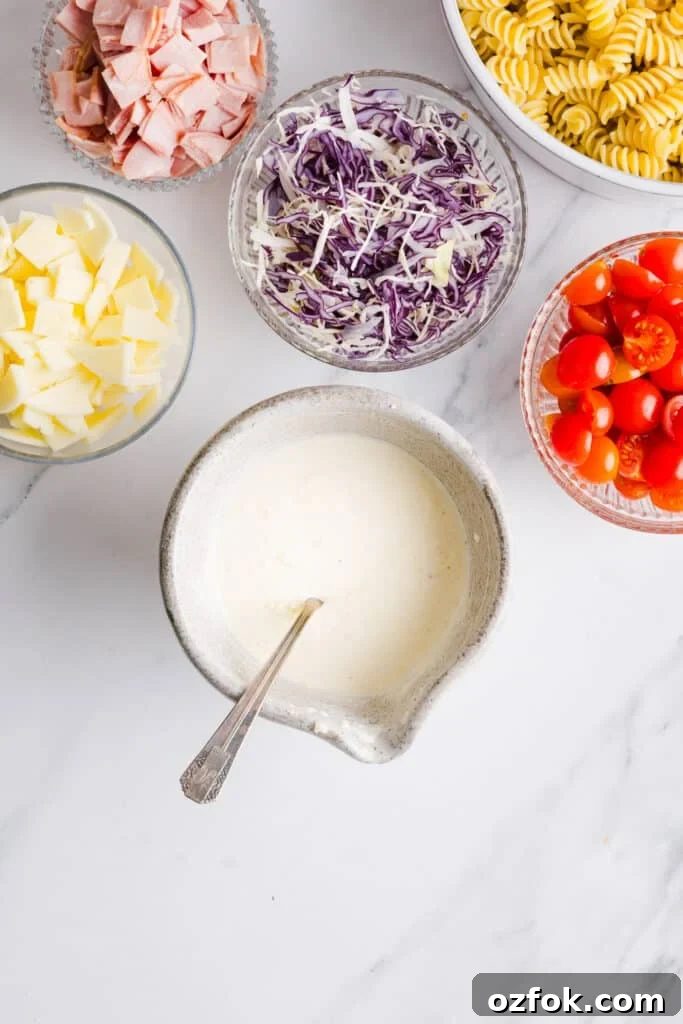 Grinder Pasta Salad Recipe with Italian Meats and Cheese 5 Grinder pasta salad dressing mixed up in a small bowl with a spoon.