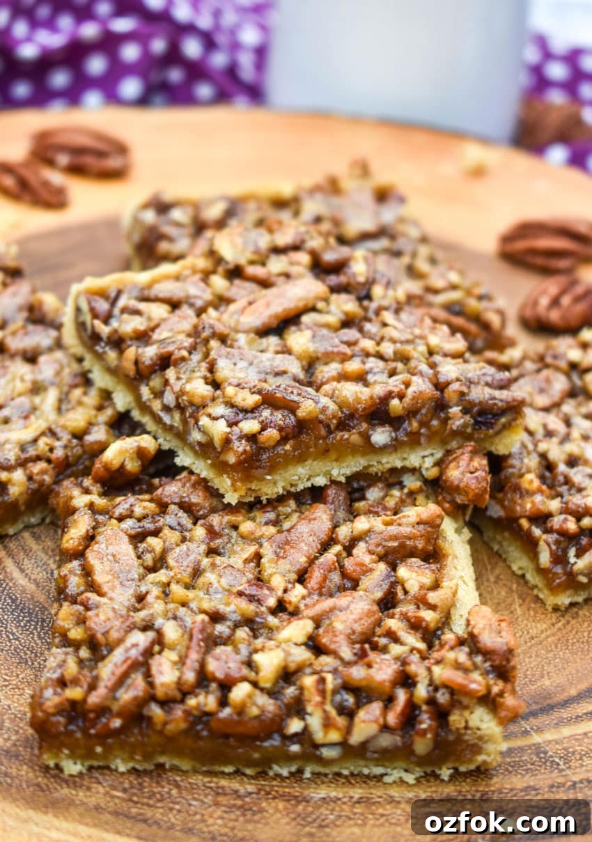 Chewy Pecan Pie Bars with Buttery Shortbread Crust 3 a stack of easy pecan bars on a wooden cutting board
