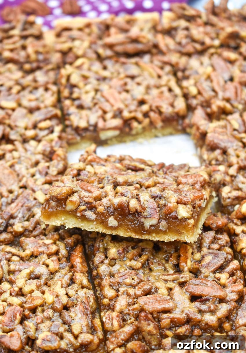 Chewy Pecan Pie Bars with Buttery Shortbread Crust 6 sliced homemade pecan pie bars on a wooden cutting board