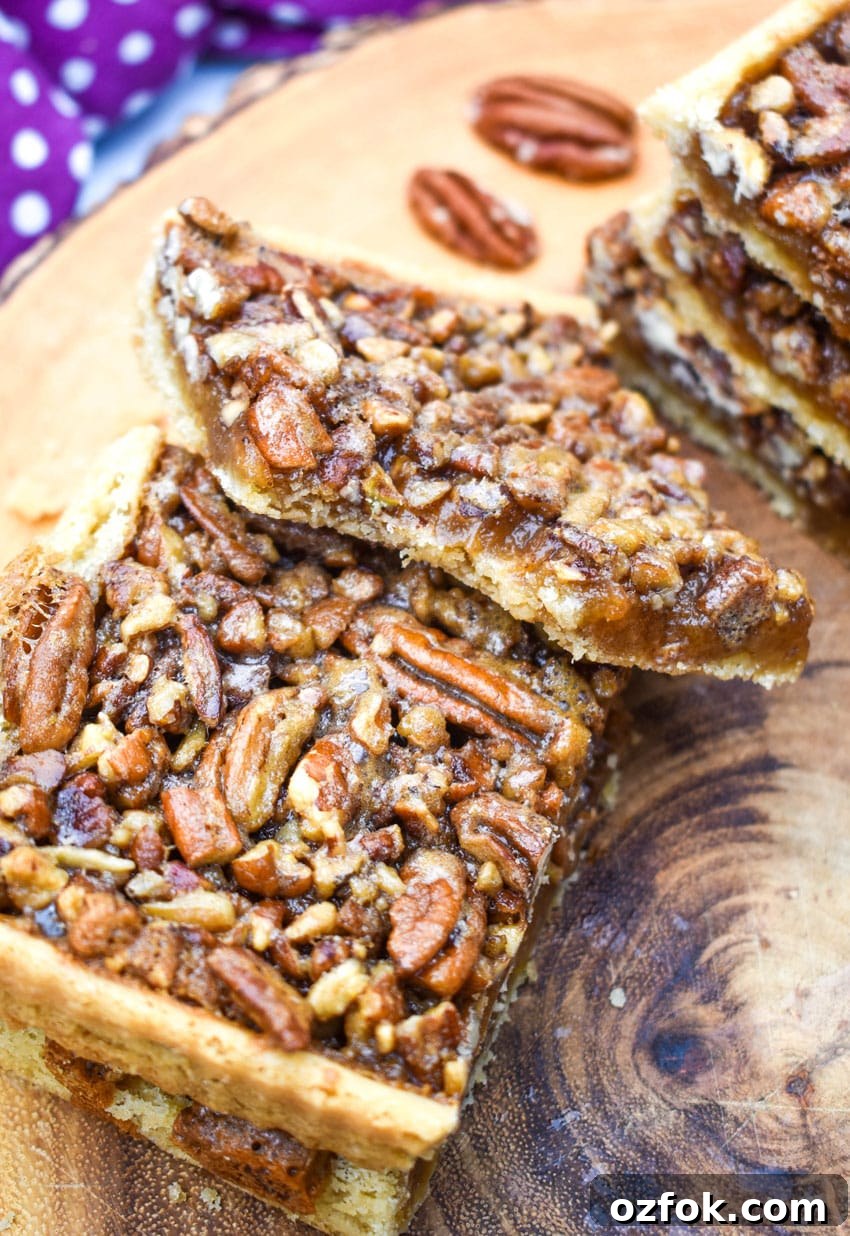 Chewy Pecan Pie Bars with Buttery Shortbread Crust 7 a stack of easy pecan bars on a wooden cutting board