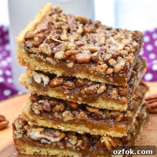 a stack of easy pecan bars on a wooden cutting board
