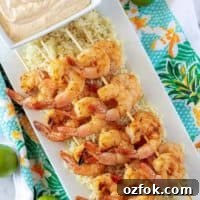 Key Lime Grilled Shrimp with Creamy Aioli Sauce 6 Grilled shrimp skewers over rice with a square bowl of key lime aioli.