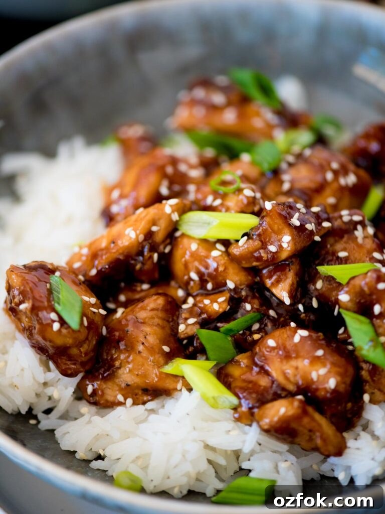 Classic Homemade General Tso's Chicken Recipe for Dinner 8 Sliced green onions over General Tso chicken and white rice in a bowl.