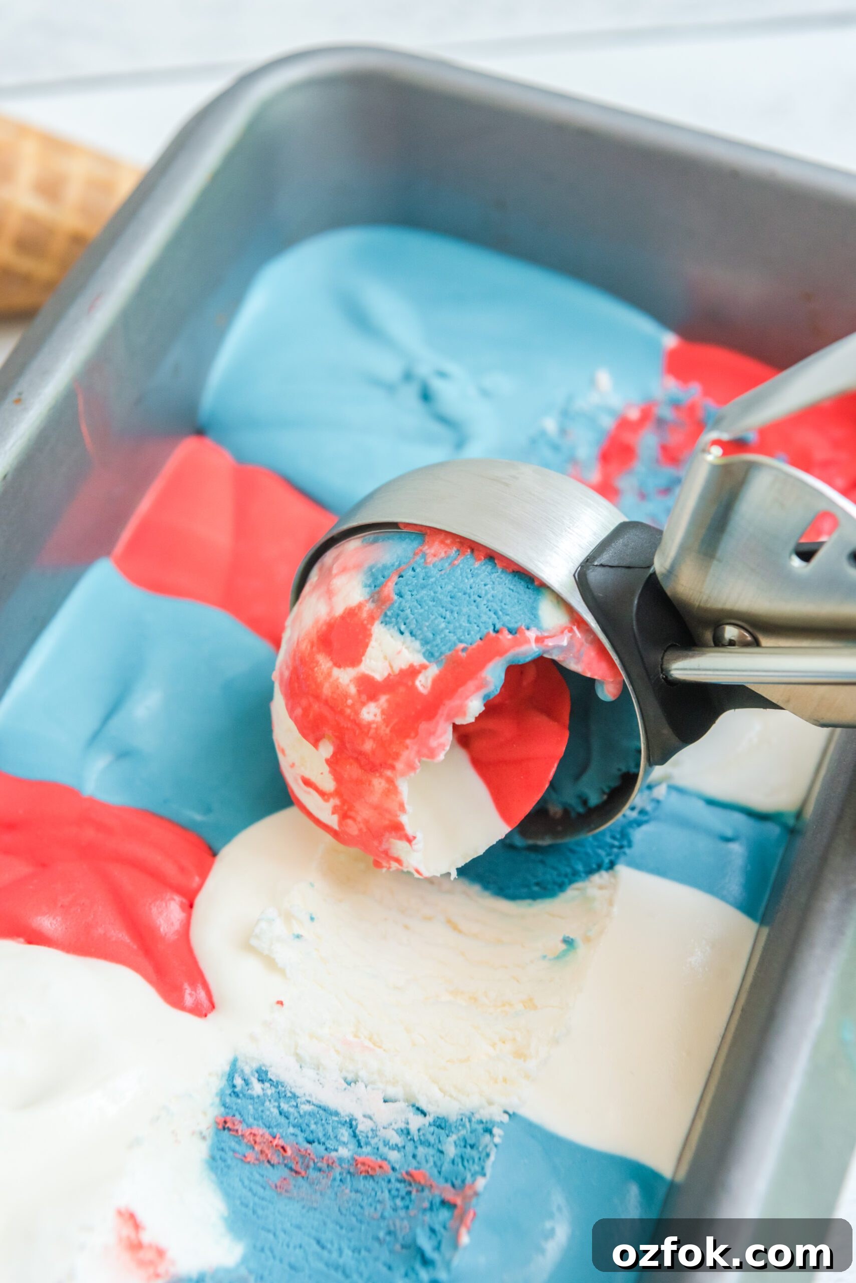 Patriotic Red, White & Blue Ice Cream Recipe for Summer Parties 5 Red, White & Blue Ice Cream in a ice cream tin pan with an ice cream scoop in it
