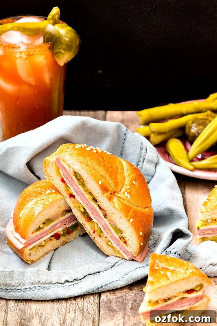 The North Carolina Muffaletta sandwich on a blue napkin next to pickled vegetables.
