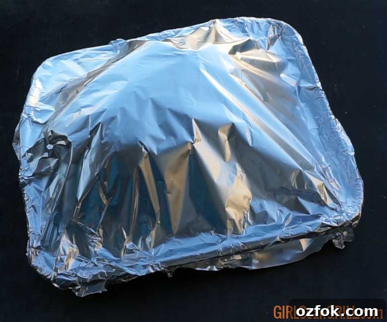 Grilled Australian Leg of Lamb Roast Recipe 7 rectangle pan covered with foil on black table