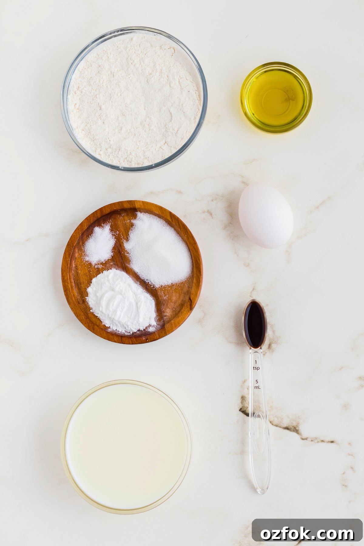Ingredients measured out in glass containers on a marble table. 
