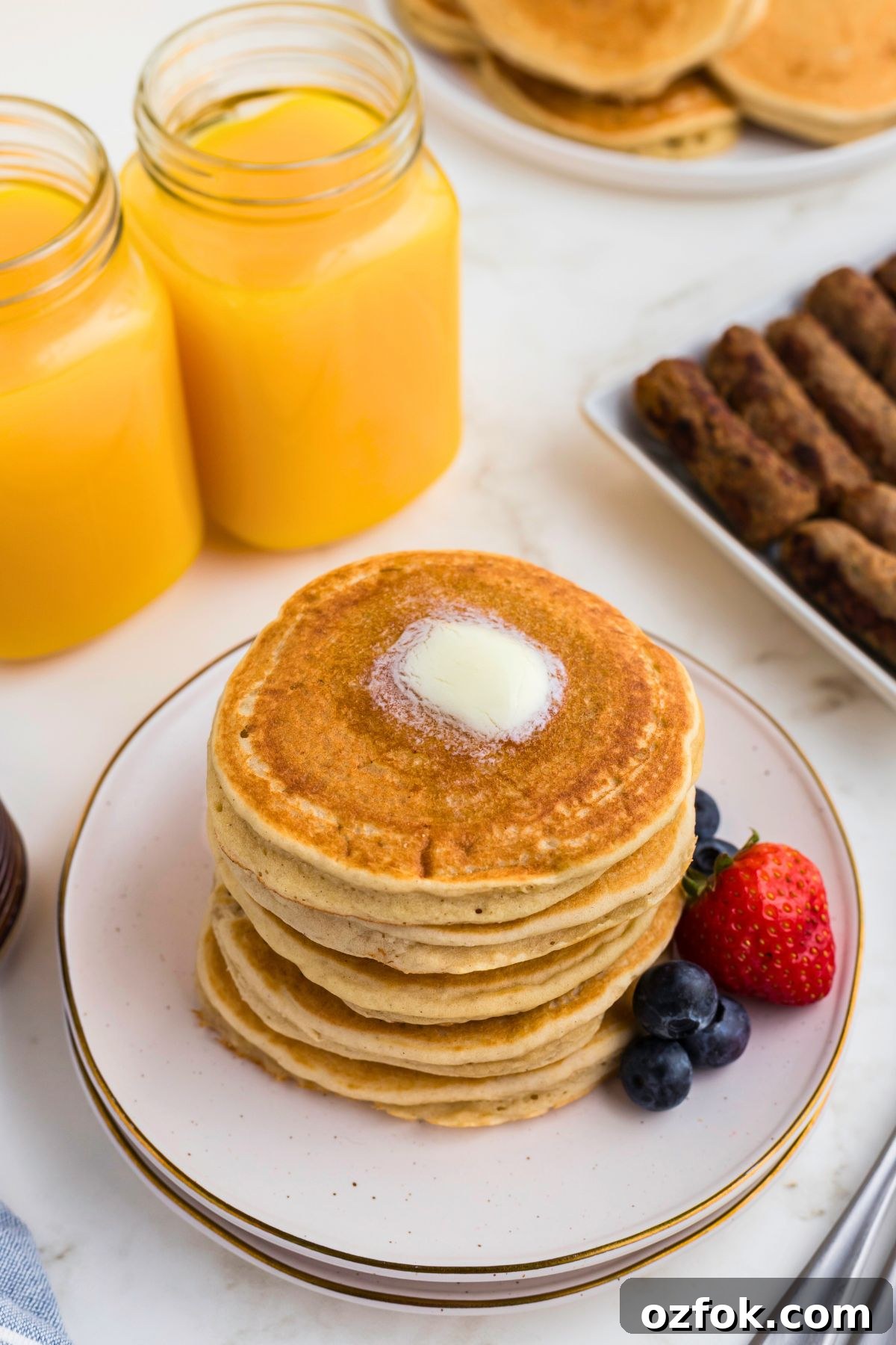 Golden gluten free pancakes stacked on a white plate. 