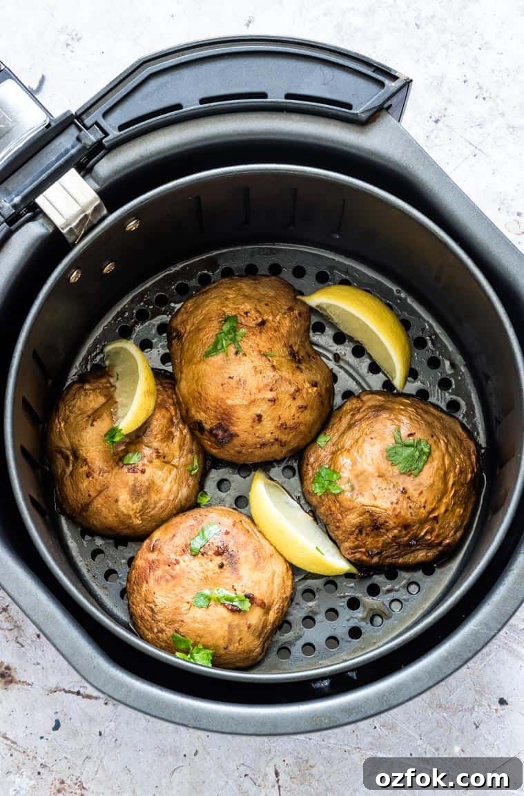 Garlic Mushroom Steak Recipe — Air Fryer & Grill (Vegan, Keto) 2 portobello mushroom steaks with lemon wedges inside the air fryer basket