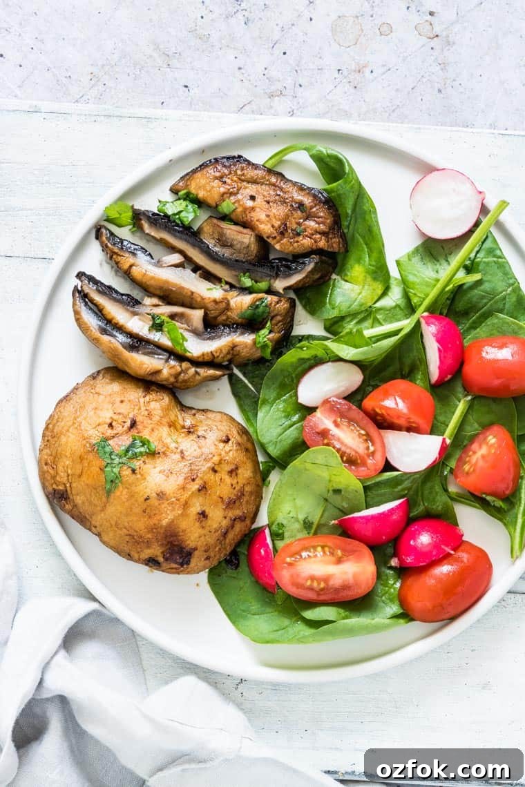 Garlic Mushroom Steak Recipe — Air Fryer & Grill (Vegan, Keto) 6 air fryer garlic mushrooms served on a white plate with a side of green salad