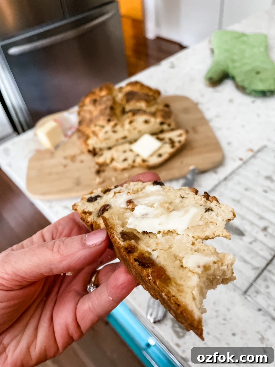 Classic Irish Soda Bread Recipe for Perfect Homemade Loaves 3 A hand holding a buttered piece of the Easy Irish Soda Bread
