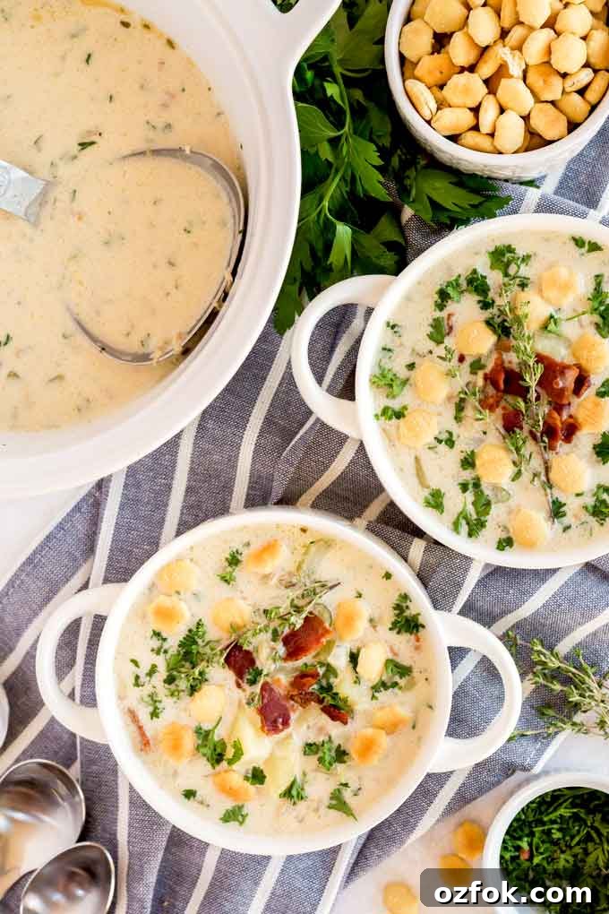 Classic New England Clam Chowder Recipe from Scratch 2 White bowls filled with creamy clam chowder and topped with crispy bacon
