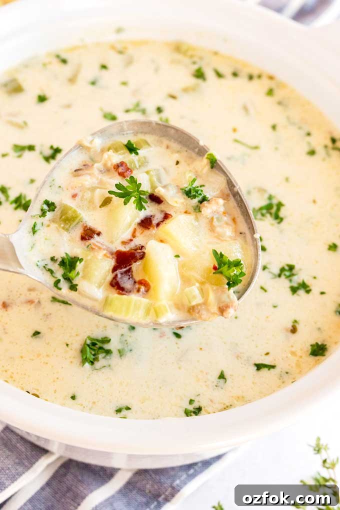 Classic New England Clam Chowder Recipe from Scratch 3 A ladle full with creamy clam chowder and topped with crispy bacon