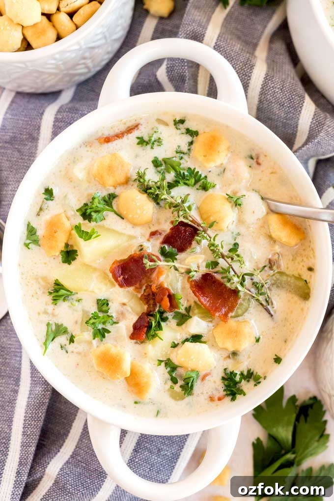Classic New England Clam Chowder Recipe from Scratch 6 Clam chowder with bacon on top in a white bowl.