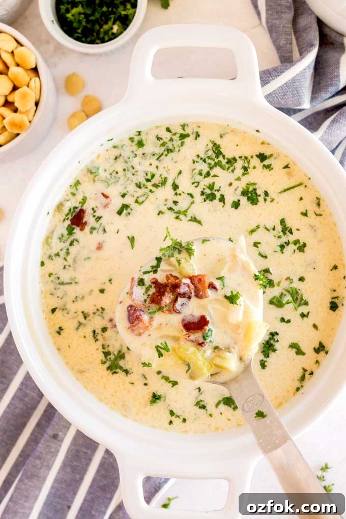 Classic New England Clam Chowder Recipe from Scratch 7 Soup lifted with a ladle from a soup pot.