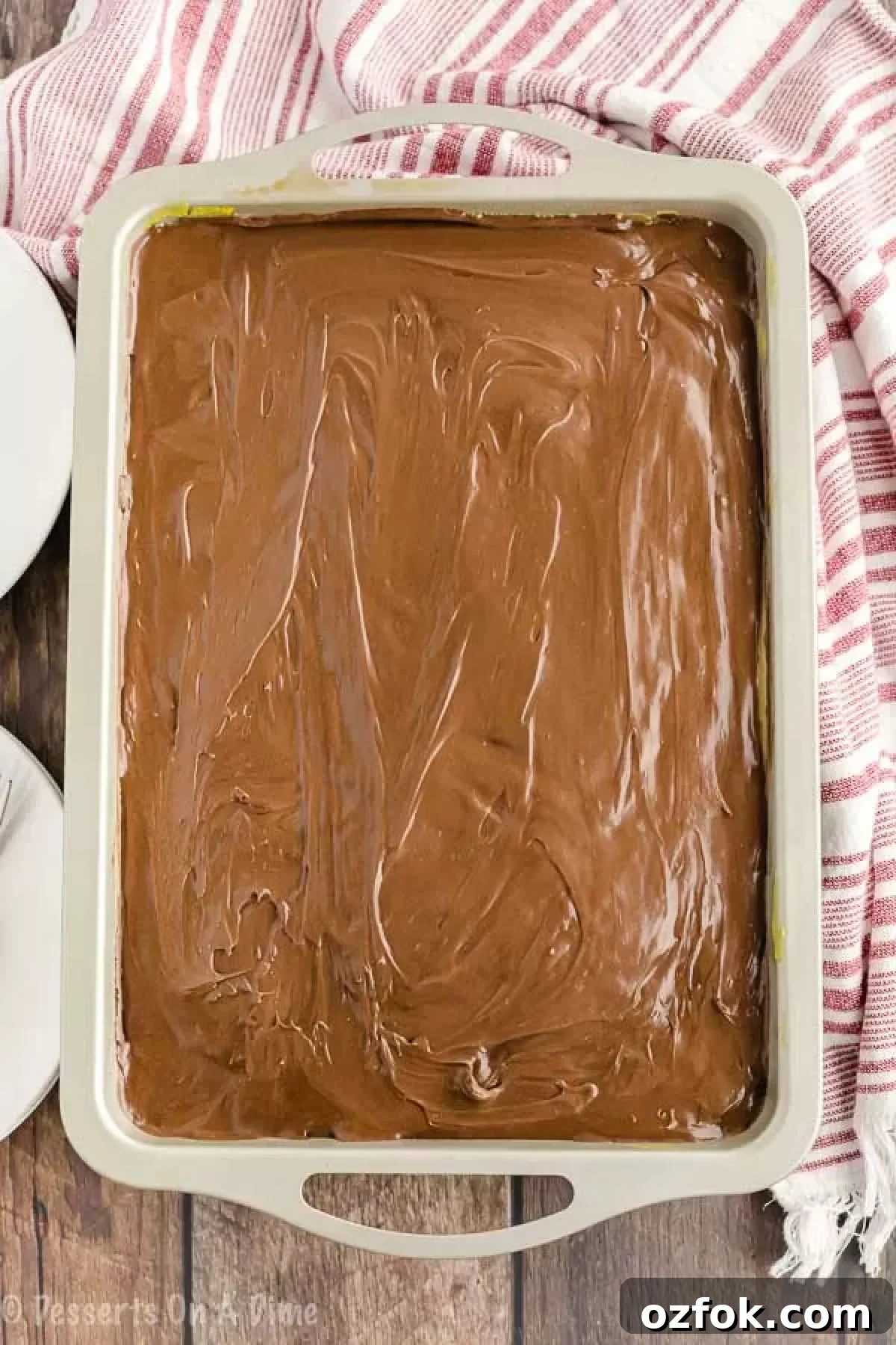 Boston Cream Poke Cake Recipe: Creamy Custard & Chocolate Drizzle 4 Chocolate frosting spread over the cake.