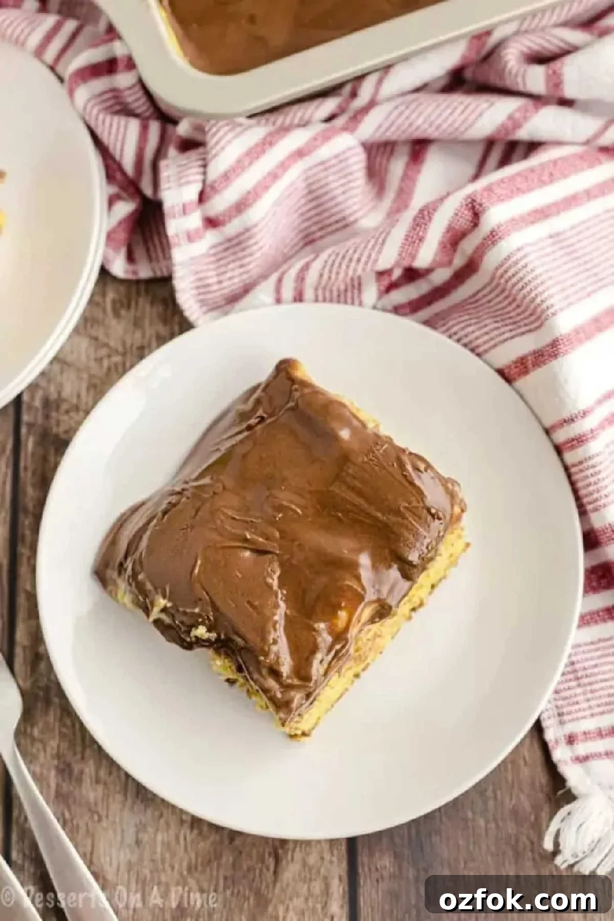 Boston Cream Poke Cake Recipe: Creamy Custard & Chocolate Drizzle 5 Slice of cake served on a plate.