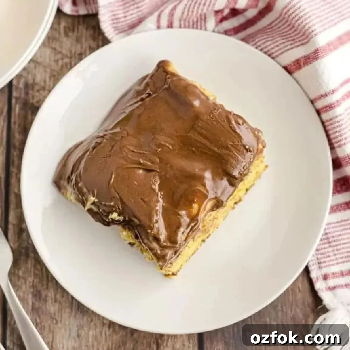 Boston Cream Poke Cake Recipe: Creamy Custard & Chocolate Drizzle 6 Boston eclair cake on a white plate.