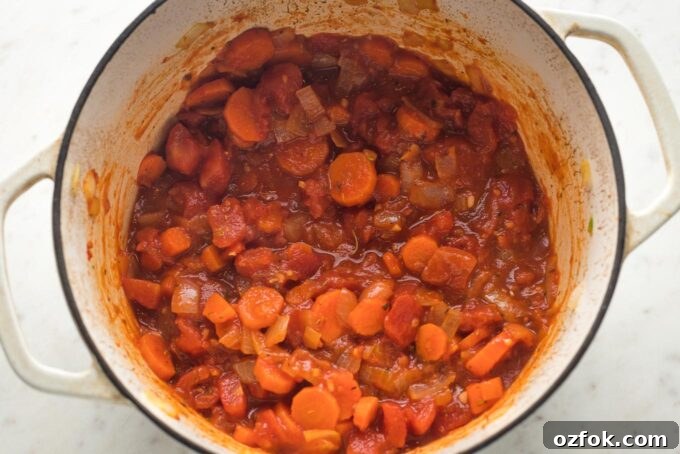Tomato paste and aromatics added to Dutch oven.
