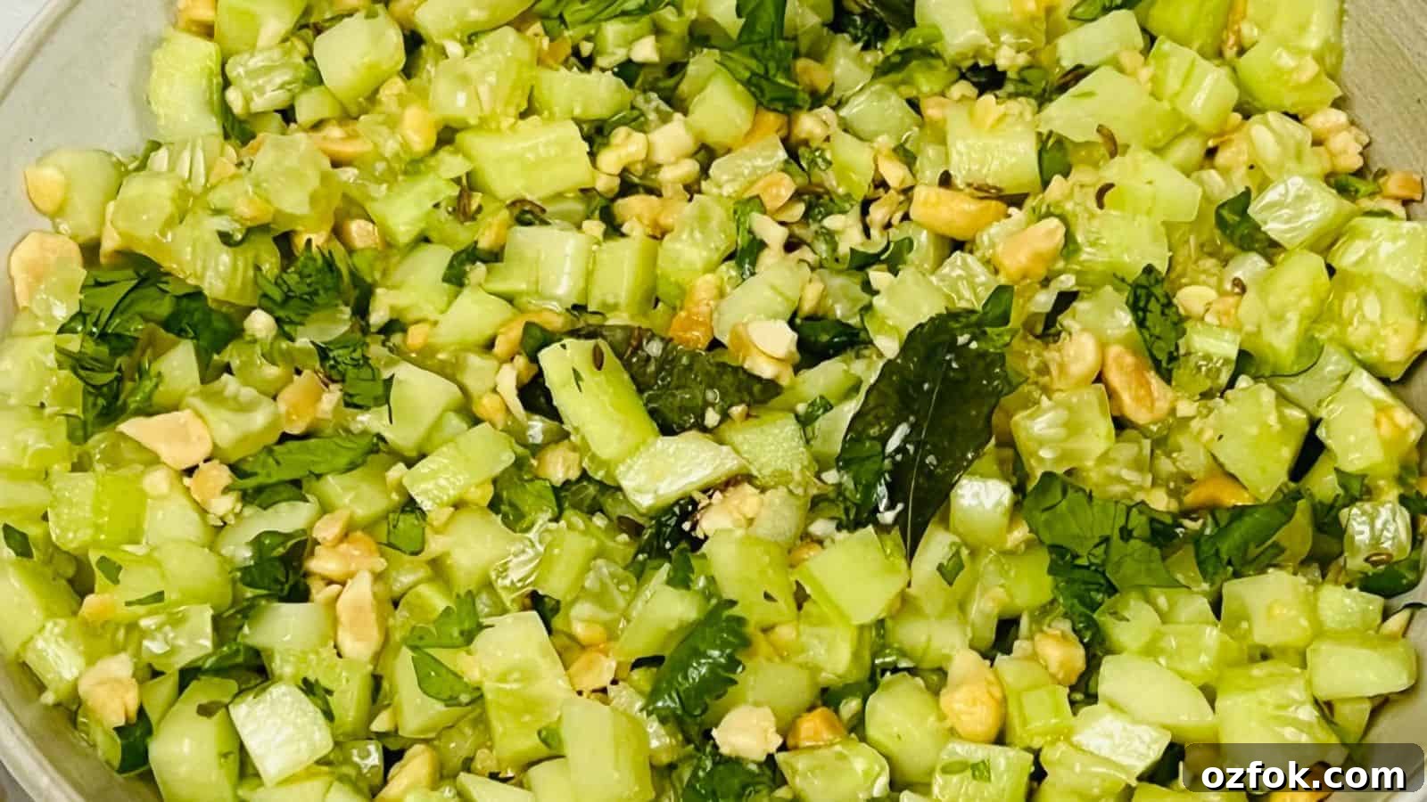 29 Irresistible Salad Recipes Everyone Will Love 11 A bowl of chopped cucumber salad mixed with nuts and fresh herbs.