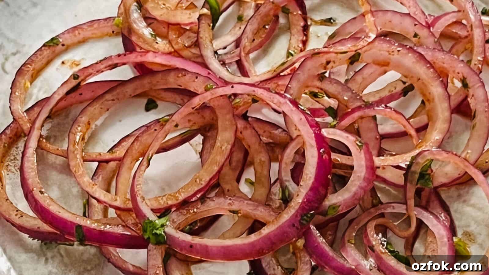 29 Irresistible Salad Recipes Everyone Will Love 22 Close-up of thinly sliced red onions, marinated with herbs and spices, placed on a white plate.