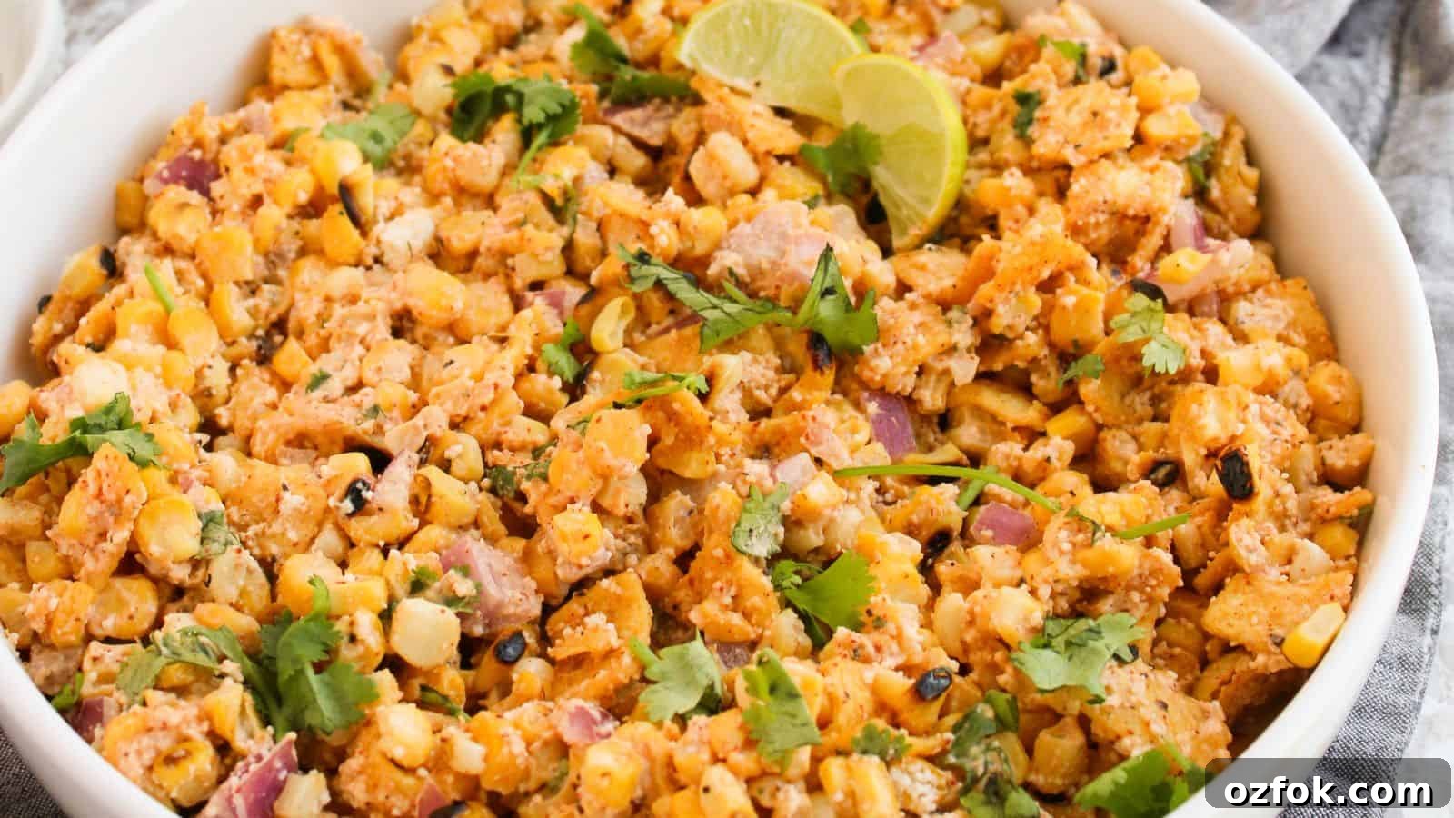 29 Irresistible Salad Recipes Everyone Will Love 23 A bowl of Mexican street corn salad garnished with lime wedges and cilantro.