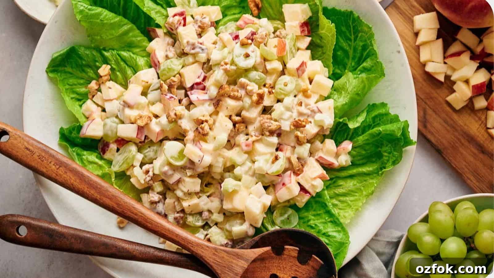 29 Irresistible Salad Recipes Everyone Will Love 30 Waldorf salad on a bed of lettuce, with salad servers resting on top.