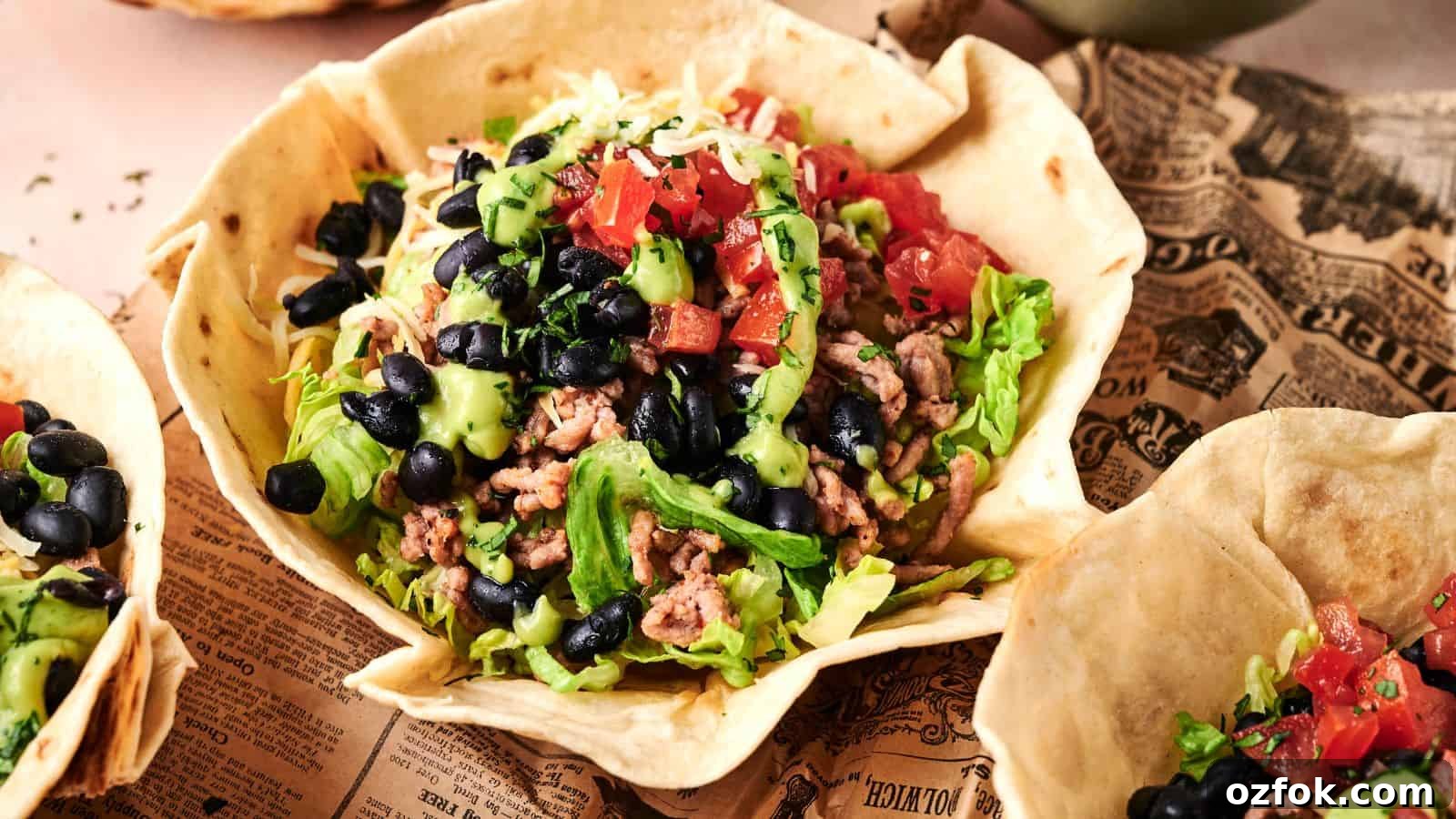29 Irresistible Salad Recipes Everyone Will Love 6 A taco salad served in an edible tortilla bowl, topped with ground meat, lettuce, black beans, diced tomatoes, avocado, and shredded cheese.