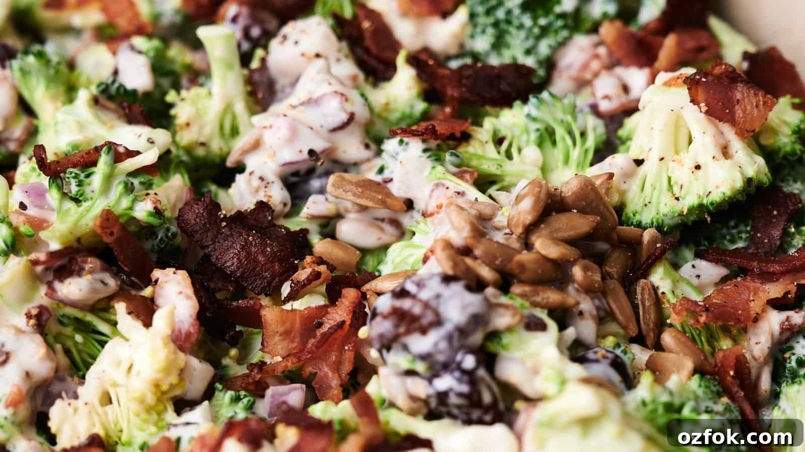 29 Irresistible Salad Recipes Everyone Will Love 9 Close-up of a delightful broccoli salad with crispy bacon, sunflower seeds, and a creamy dressing. Mixed ingredients are visible in detail, showcasing the vibrant textures and colors of this fresh broccoli salad.